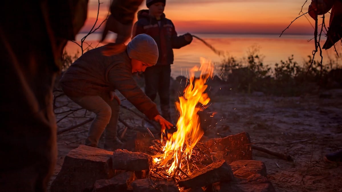 Children gathered around a campfire at night
