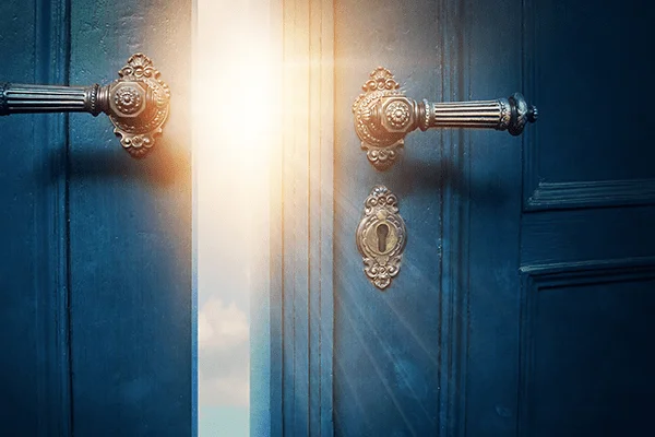 Believe everything you think: light pouring through a partly open blue door